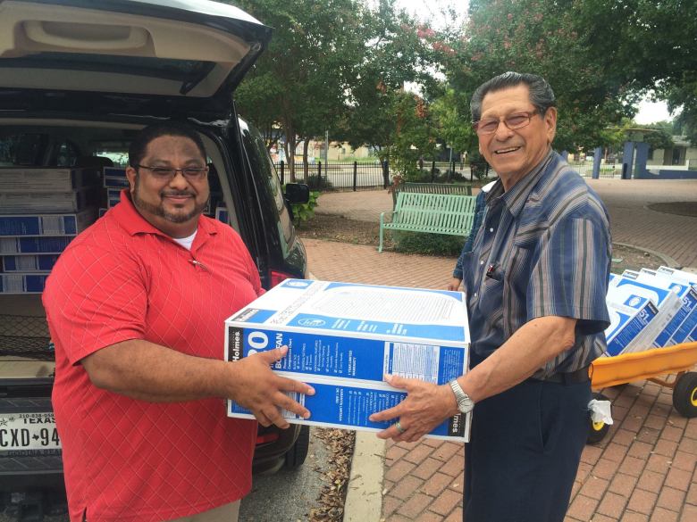 Benjamin Godina unloads 50 donated box fans with his father, Alfonso Godina, to deliver them to the Good Samaritan Community Services Senior Center in 2017.