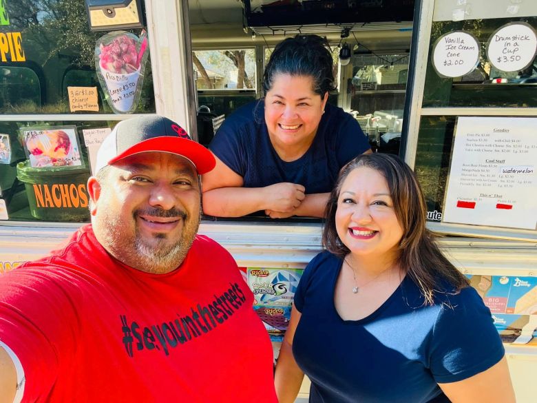 Benjamin and Amanda Godina (front) pose with Roxy Faz and her food truck, Roxy's Mobile Snacks, during an event the Godina's organized to give away free raspas to students and teachers on the South Side last year.