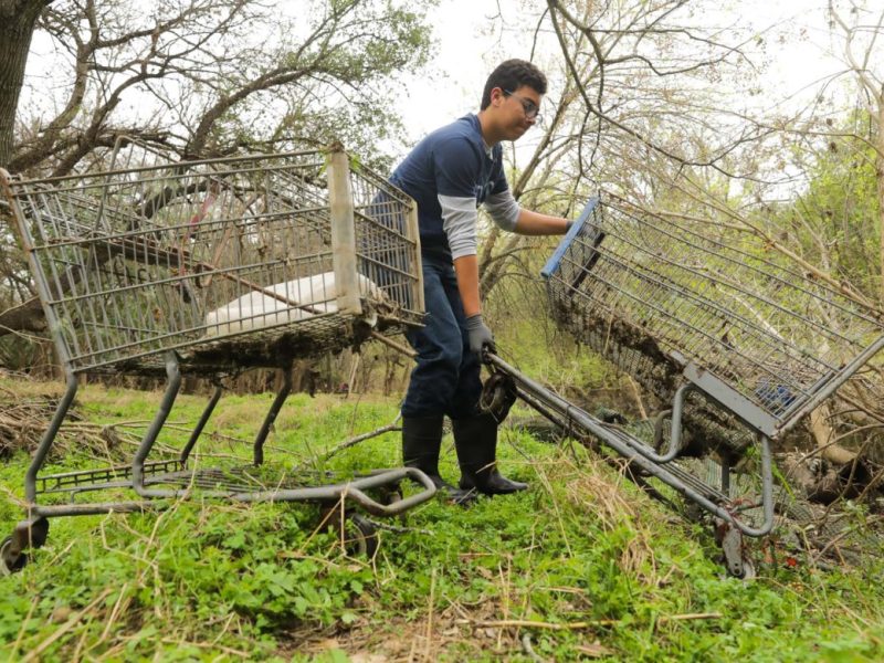 Joshua Caudill extracts two shopping carts from Salado Creek during the annual Basura Bash in efforts to clean up waterways throughout San Antonio.