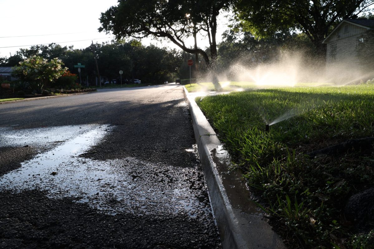 Water flows into the street while sprinklers water a lawn in Alamo Heights Tuesday.