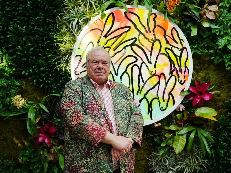 Artist Hunt Slonem stands in front of a painting from his art exhibit Huntopia at the San Antonio Botanical Garden.