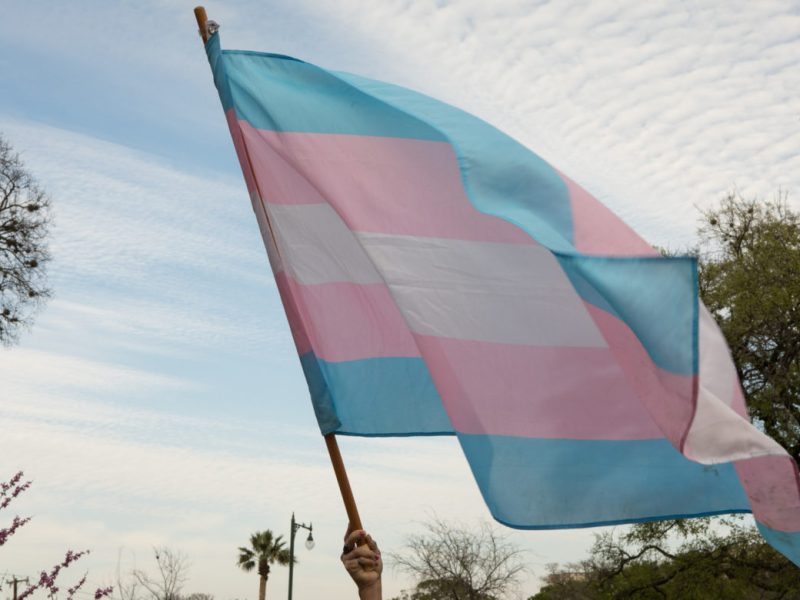 A transgender equality flag is raised during a rally at Crockett Park in 2018.