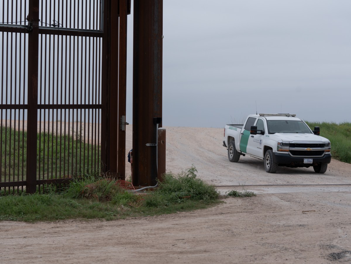 A border patrol truck drives through a segment of the border wall in Brownsville, Texas.