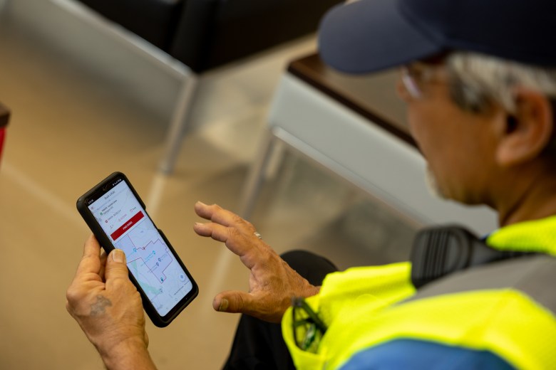 Eladio Diaz navigates the VIA Link app to request a ride to his job at Toyota supplier Forma Automotive.