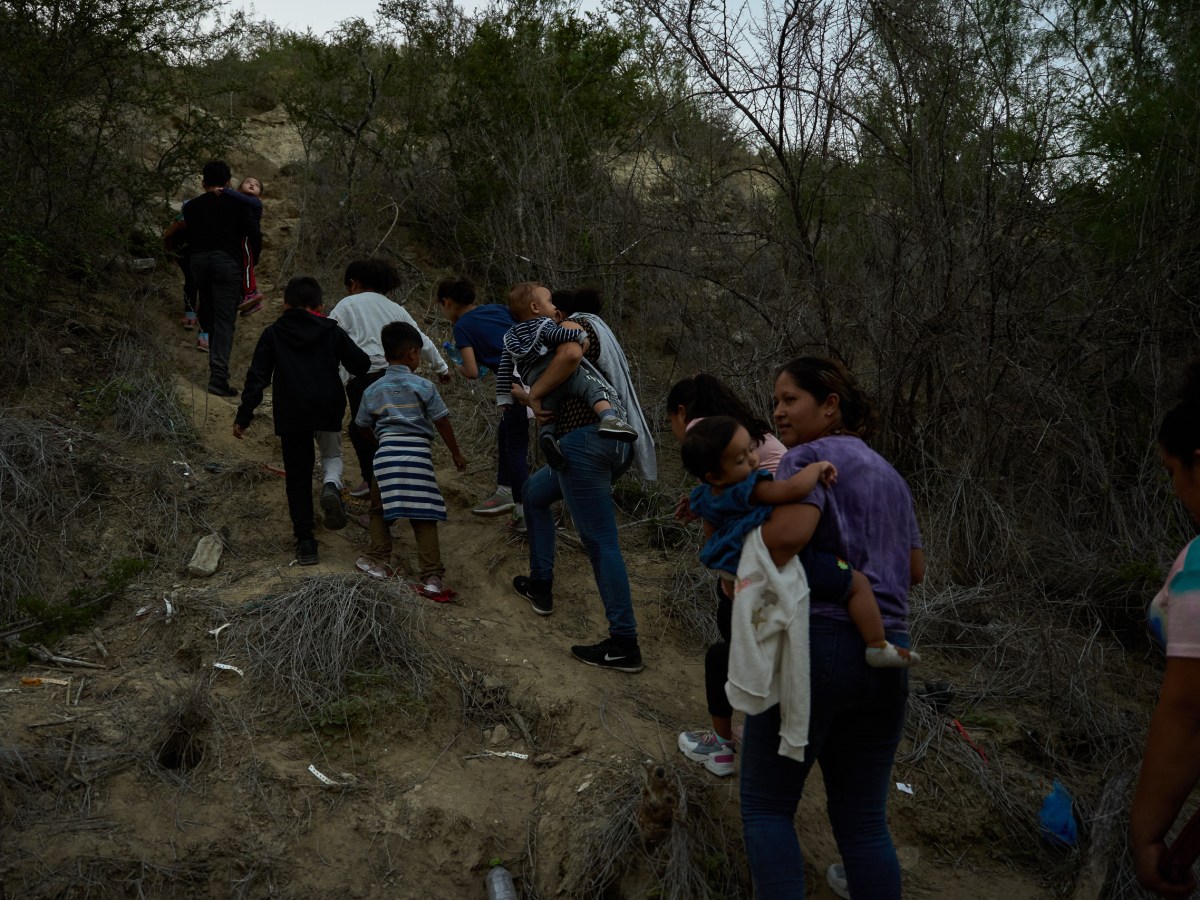 A group of immigrants hike up the banks of the Rio Grande in Roma, Texas to turn themselves in to authorities after crossing the border illegally.