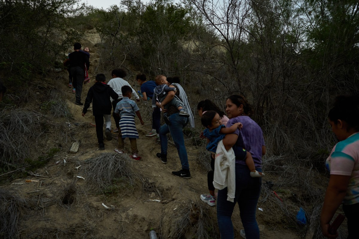 A group of immigrants hike up the banks of the Rio Grande in Roma, Texas to turn themselves in to authorities after crossing the border illegally.