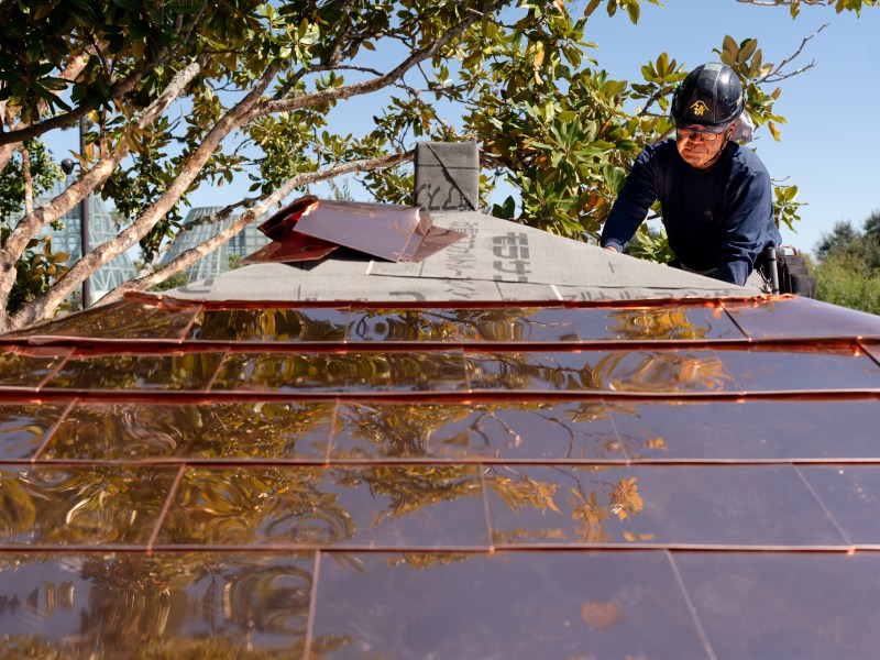 A craftsman from Japan works on the restoration of the azumaya in the Kumamoto En Japanese Garden at the San Antonio Botanical Garden on Friday afternoon.