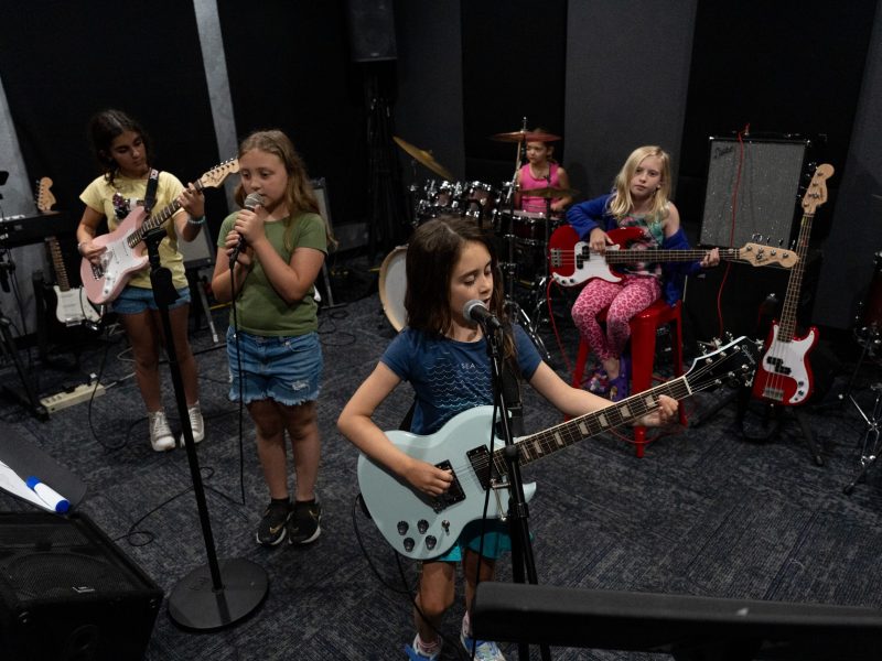 From left: Ana Quagliara, Antonia Froelich, Juliana Hawkins, Annabella Varley, and Athena Pate play a cover of Dreams by Fleetwood Mac during summer camp at School of Rock.