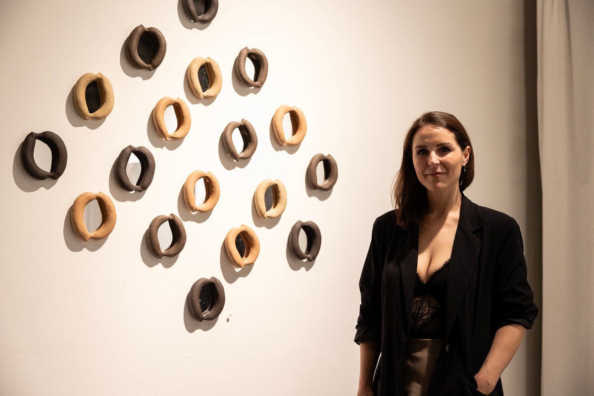 Anita Becerra poses for a portrait with some of her ceramic works during the opening night for her new installation at the Mercury Project Thursday night.