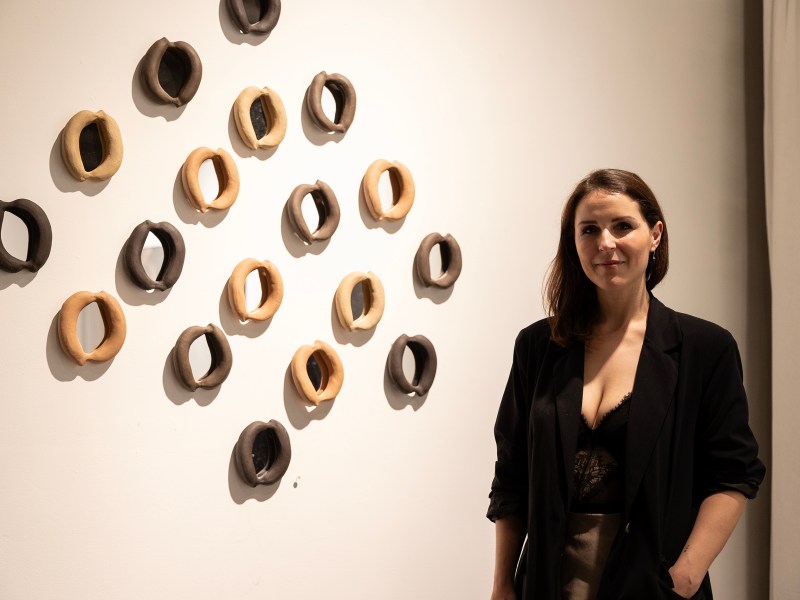 Anita Becerra poses for a portrait with some of her ceramic works during the opening night for her new installation at the Mercury Project Thursday night.