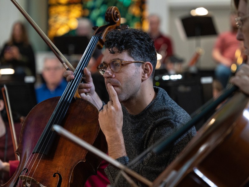 Ignacio Gallego, cellist with the San Antonio Philharmonic and Agarita, reads his sheet music during a rehearsal at the First Baptist Church of San Antonio for the philharmonic.