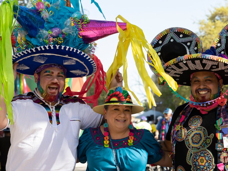 John Paul Calvo (left) and Uriel Diez pose with Maria Mckeown during Fiesta Fiesta in Hemisfair Thursday.