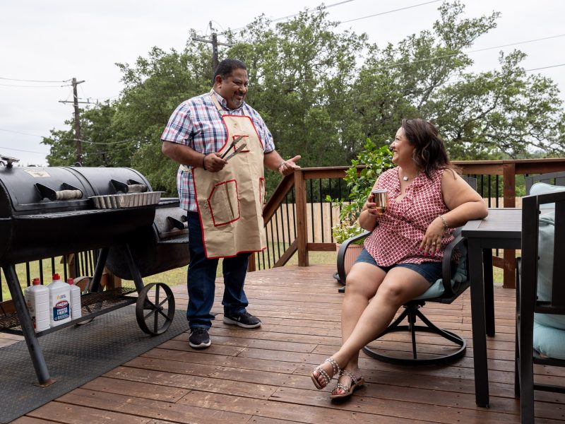 Benjamin Godina and his wife Amanda Godina prepare for a family BBQ at their house in Alamo Ranch Friday.