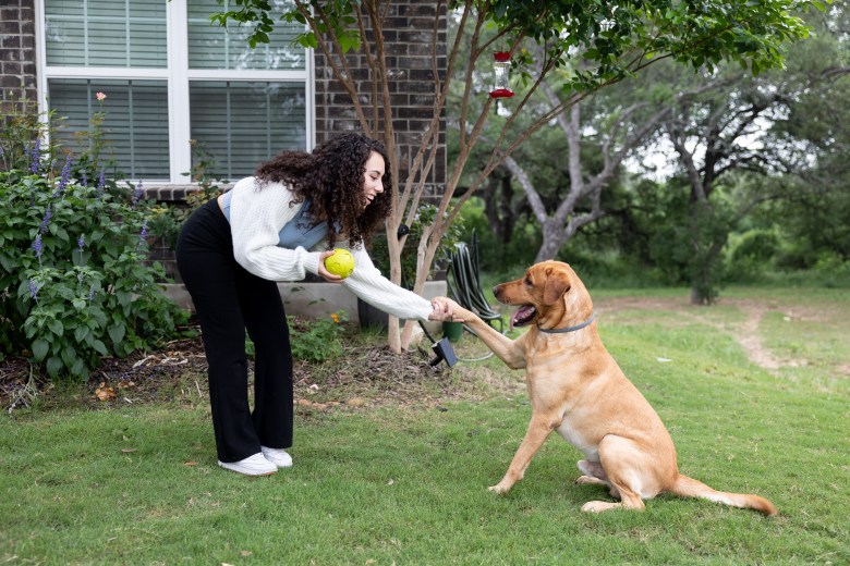 Leilah Gaitain plays with her dog Roscoe in their front yard Thursday.