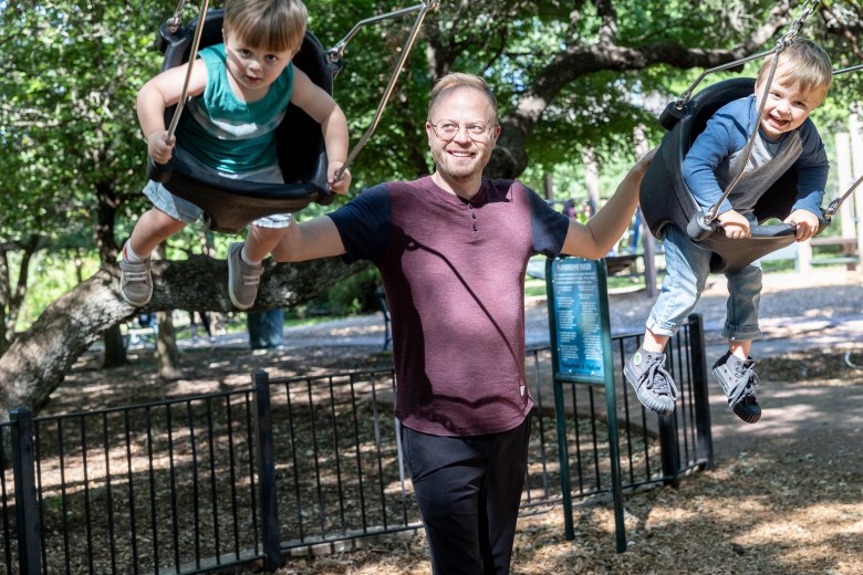 Parker Dixon pushes his sons Woody Dixon, 2 and Truman Dixon, 3 on the swings at the playground at Landa Library Thursday.