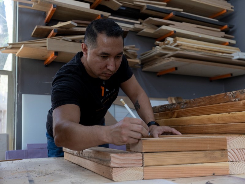 Derek Aguilar measures and sorts slabs of wood that will he will use to construct 50 food pantries that will be placed around San Antonio in partnership with Community First Health Plans.