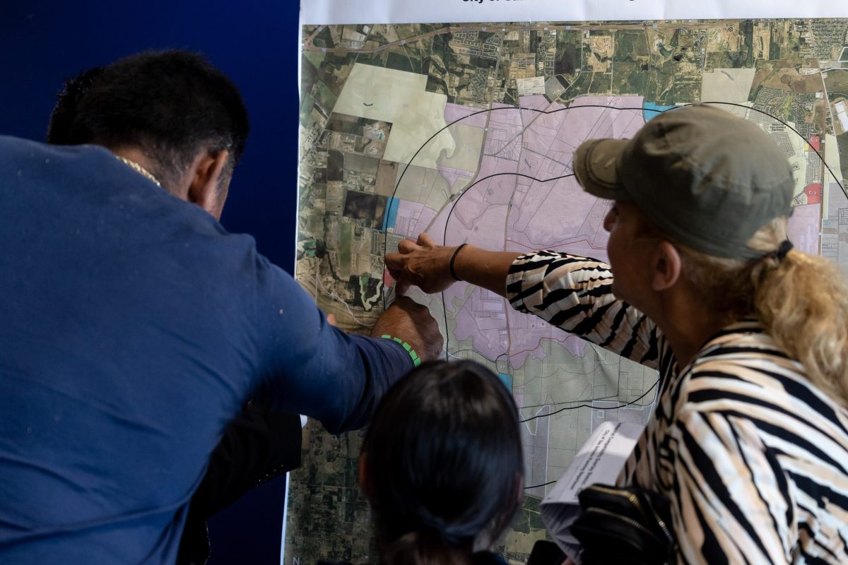 Zenon Solis, with the City’s Planning Department, helps Aleida Montellano and her family understand that since their home is in Bexar County, they will not be impacted by the proposed industrial zoning overlay within two miles of Toyota plant.