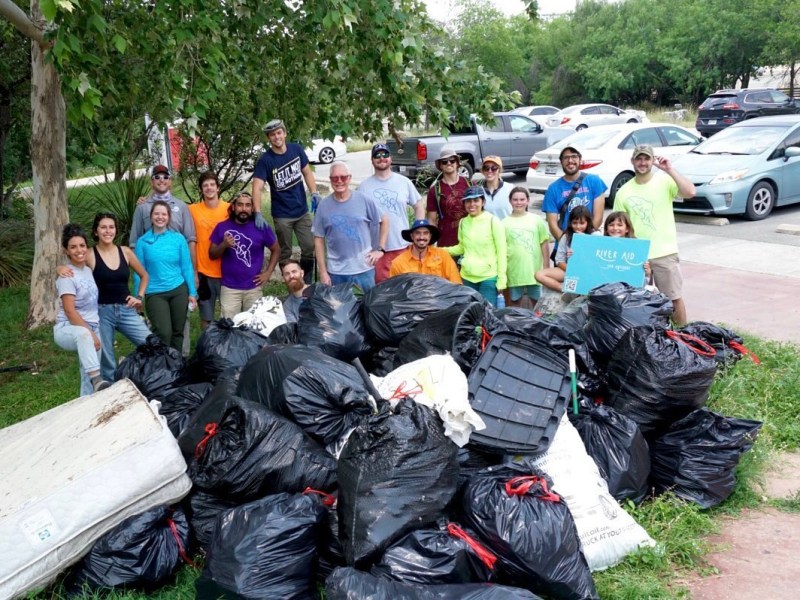 Volunteers pose with their trash haul after a cleanup at Tobin Park.