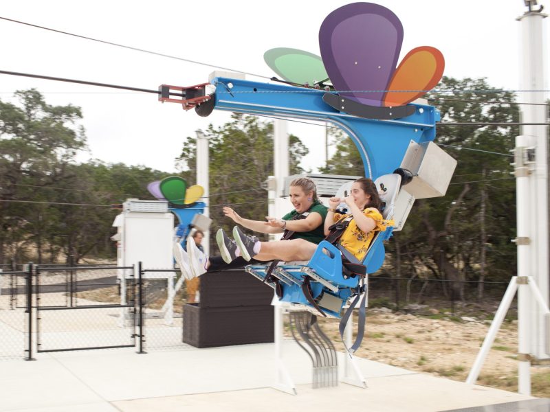 Brooke Kearney, left, chief mission officer with Morgan's Wonderland rides the new zip line at Morgan's Wonderland Camp with Briana Troy.