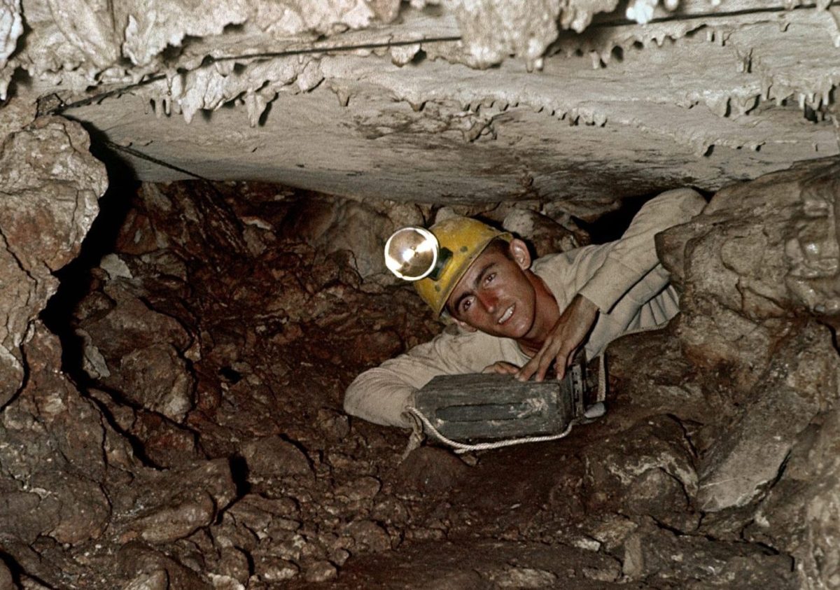 Orion Knox, Jr. crawls through a small space in the cave system that is now Natural Bridge Caverns in September 1961.