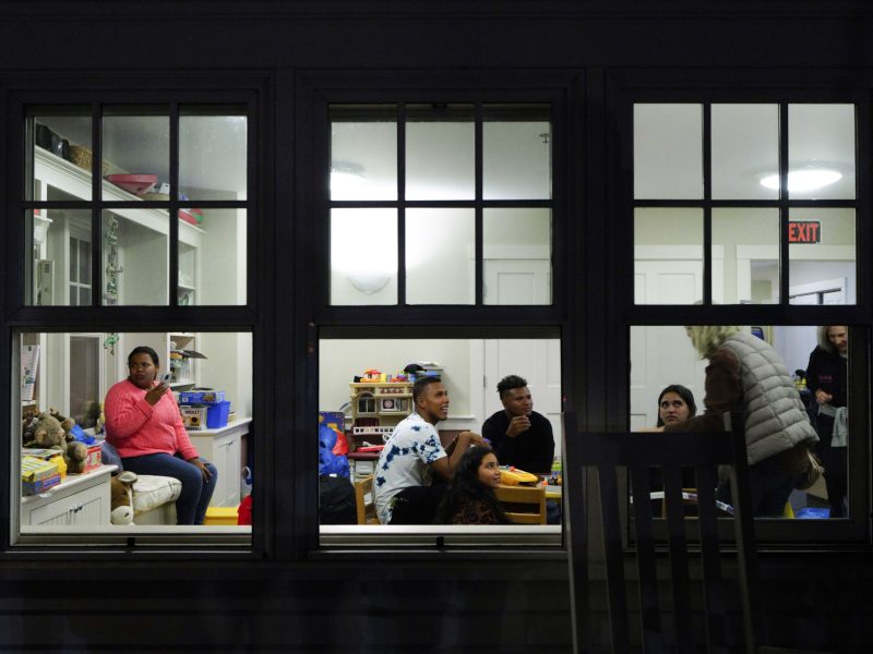 Martha's Vineyard, MA - September 15: Venezuelan migrants and volunteers gather in St. Andrew's Parish House. Two planes of migrants from Venezuela arrived suddenly the previous night causing the local community to mobilize and create a makeshift shelter at the church. (Photo by Carlin Stiehl For The Boston Globe via Getty Images)