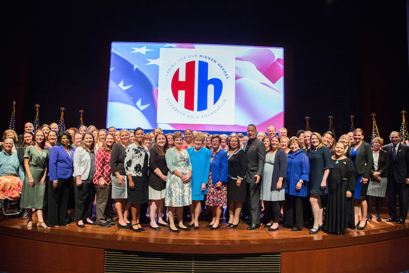 Hidden Heroes speakers and more than 60 Dole Caregiver fellows on stage with Senator Dole and Tom Hanks. Photo by Lisa Nipp.