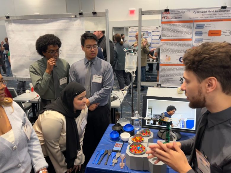 Sara Mustafa examines the OMAR in action as her group member Caleb Champion explains how the robot works. Fellow group members Josie Torres, Damario Harris, and Rafael Robles also look on. Mustafa was inspired to create the assistive robot by the loss of her uncle in 2016. She and her five UTSA classmates who built the robot showcased it at the UTSA Fall 2023 Tech Symposium last week, where they received 3rd place and $2,000 for their design.