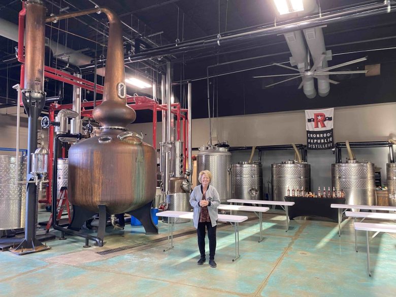 “Mother of Texas Whisky” Marcia Likarish shows off the copper pot still that gives Ironroot Republic distillery whiskeys their particular mouthfeel.