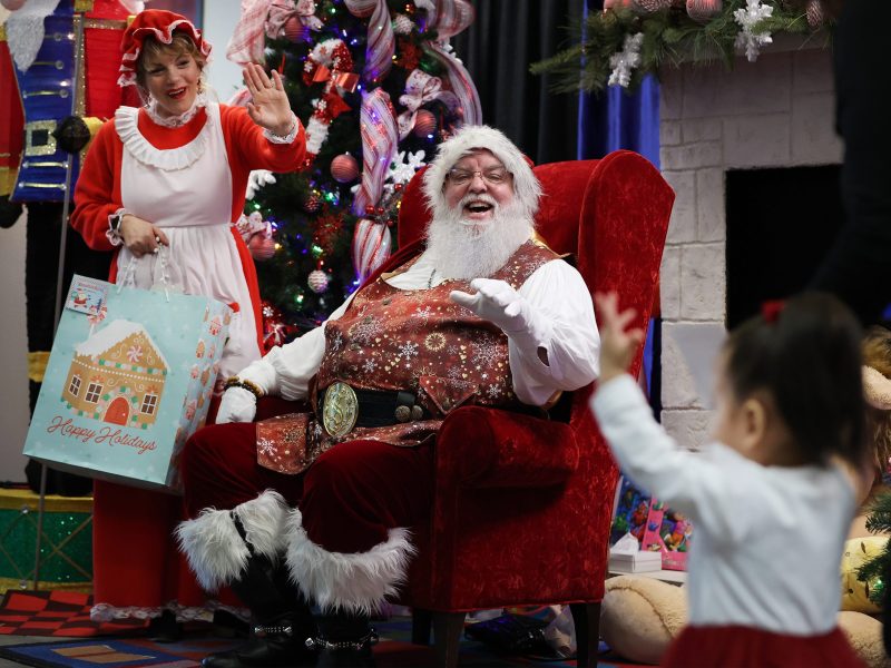 A young child reacts as she receives greetings from Mr. and Mrs. Santa Claus as about 2,000 kids from Child Protective Services receive Christmas gifts -- of their own choosing -- on Saturday, Dec. 9, 2023 at Summit Church.