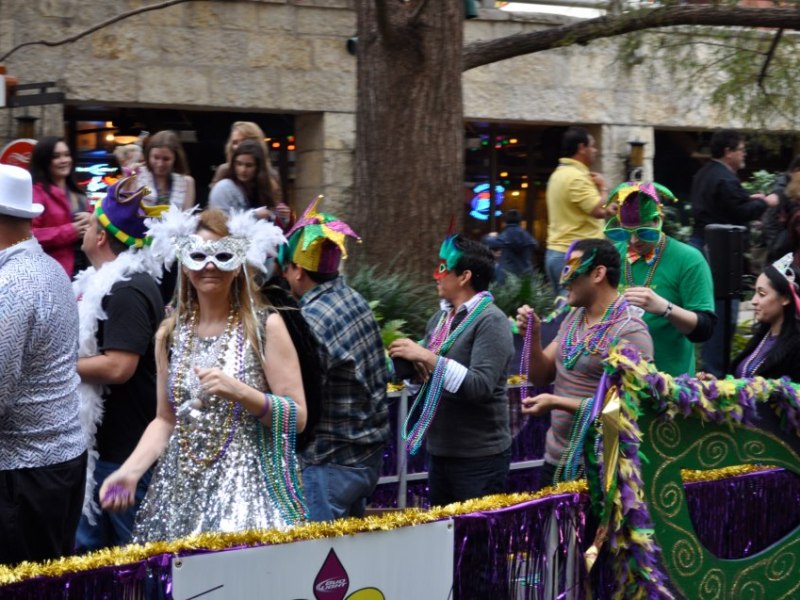 Dozens of river barges filled with costumed bead-tossers pass by crowds of revelers for the 2013 Mardi Gras River Parade. Photo by Iris Dimmick