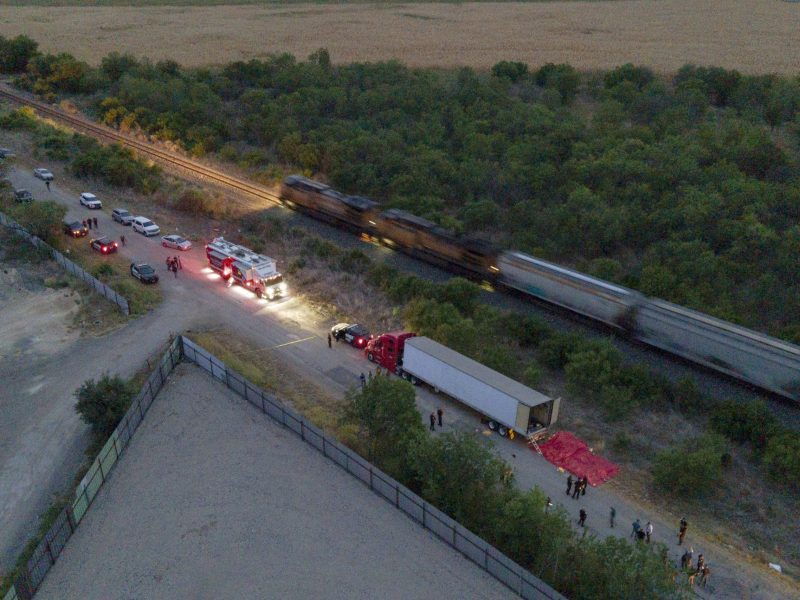 Law enforcement officers investigate the area in Southwest San Antonio in June where 53 people who had been traveling in a tractor-trailer died.