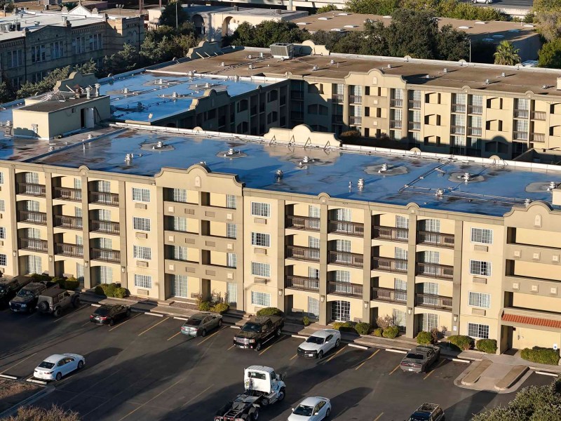 The ground lease of the former Holiday Inn at 318 W. César Chávez Blvd., now used as low-barrier shelter for people experiencing homelessness, has been purchased by McCombs Enterprises.