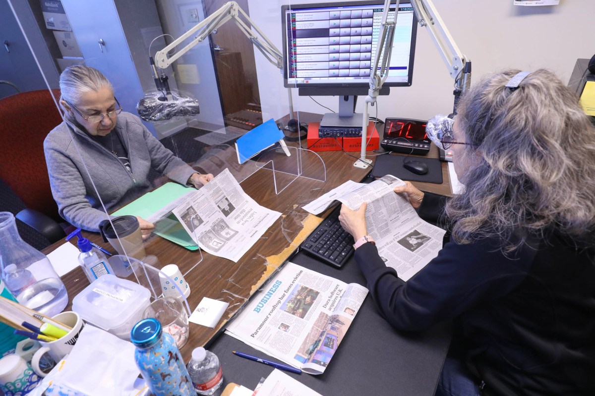 Volunteers Veronica Salinas, left, and Laura Rodriguez read news stories from the San Antonio Express News as part of Owl Radio which aids the visually impaired with audible daily news offerings.