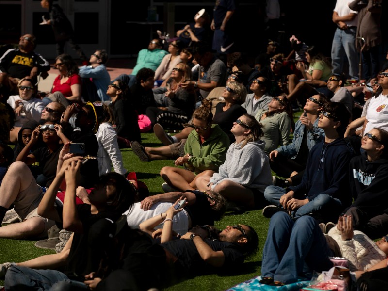 Visitors at Scobee Education Center and Planetarium gaze towards the sun and moon during the moment of annularity of the 2023 eclipse.