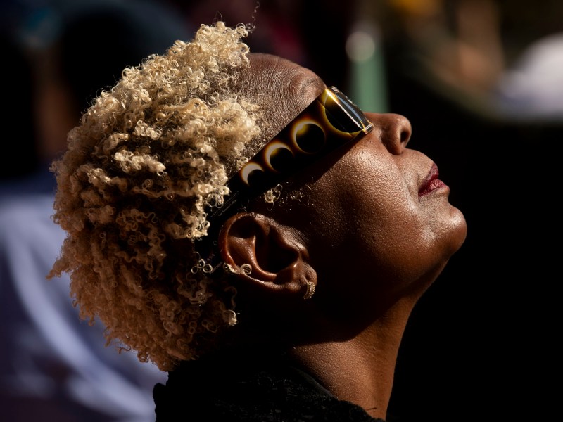 Visitors at Scobee Education Center and Planetarium gaze towards the sun and moon moments before annularity of the 2023 eclipse.