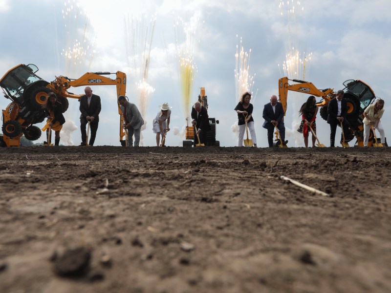 JCB family and employees along with local officials use golden shovels to officially break ground on the future manufacturing facility for construction equipment.