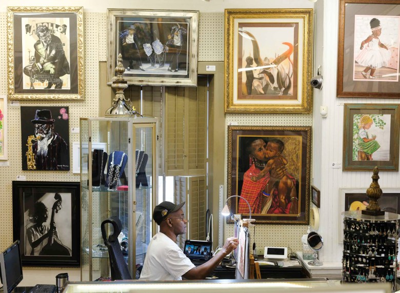 Ronney Stevens, an artist and co-op member of the Little Studio Gallery at La Villita, mans the shop while working on a piece of art working featuring sunflowers.