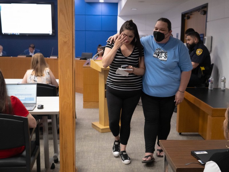 Nicole Hammer, left, is comforted by Kayla Miranda following her public comment to the Opportunity Home board of trustees.