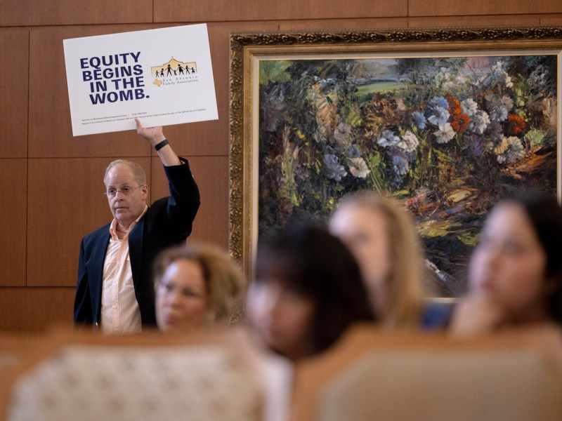 Michael Knuffke, a San Antonio Family Association member, holds up a sign in protest of the City's reproductive justice fund.