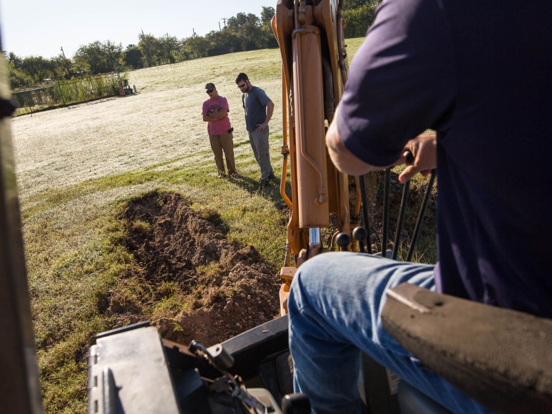 Reba Kistner Environmental employees Cyndi Dickey and Mark Luzmoor observe as backhoe operator Dean Hillman carves into the flat land where the acequia eventually was found.