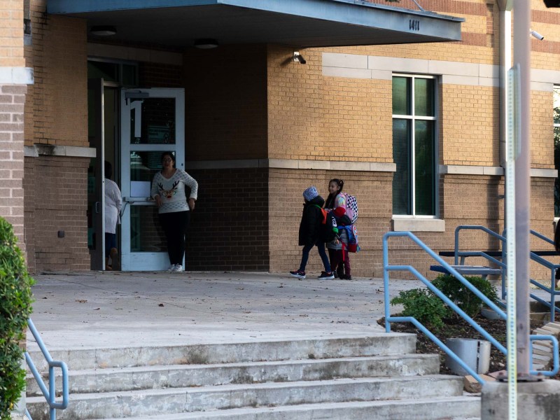 Children arrive to Beacon Hill Academy, one of the 15 schools selected to be closed by the SAISD board of trustees.