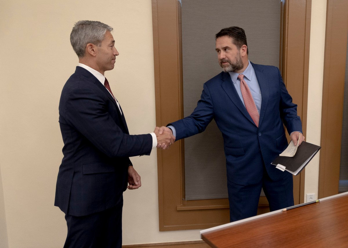 Mayor Ron Nirenberg, left, shakes hands with City Manager Erik Walsh following the successful passing of the police contract.