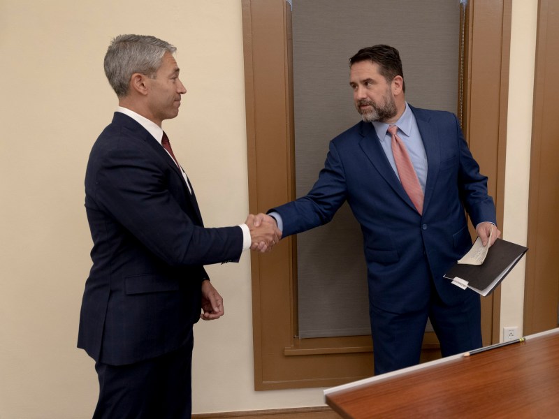 Mayor Ron Nirenberg, left, shakes hands with City Manager Erik Walsh following the successful passing of the police contract.