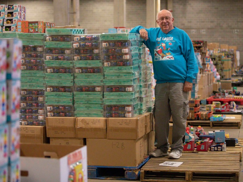 Elf Louise Exectuve Director Bill Harrison stands on a pallet of Christmas toys as the local nonprofit prepares for another holiday season.