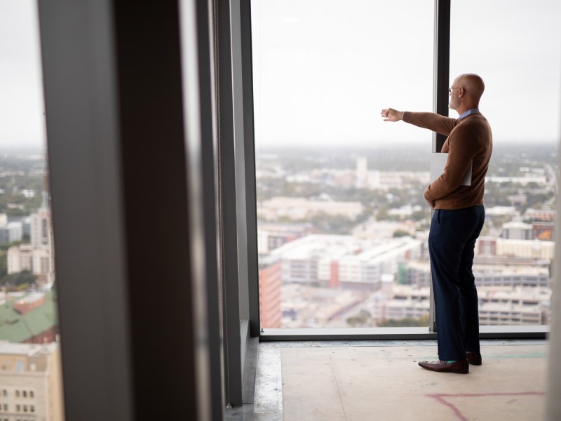 Weston Urban President Randy Smith points toward ongoing and incoming projects surrounding downtown San Antonio from the 24th floor of Frost Tower.