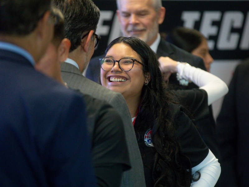 A H-Tech student places a ceremonial pin on Alamo Colleges Chancellor Mike Flores.