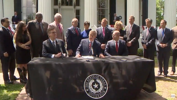 Texas Governor Greg Abbott (center) addresses media in Austin to announce substantial progress made by the Texas Legislature on education finance reform and property taxes.